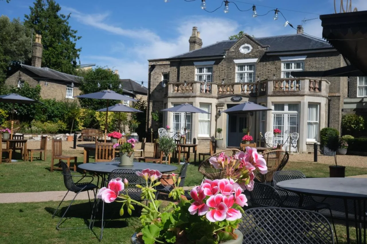 a garden with tables and chairs and a building at The Gonville Hotel, a member of Radisson Individuals in Cambridge