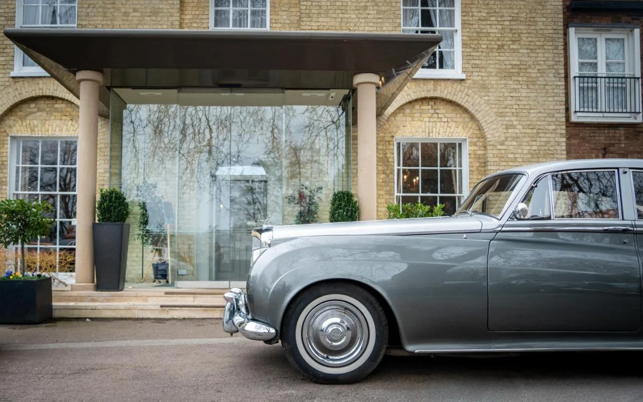 an old car parked in front of a building at The Gonville Hotel, a member of Radisson Individuals in Cambridge