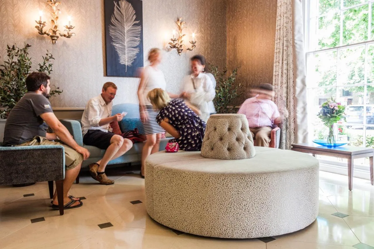 a group of people sitting in a living room at The Gonville Hotel, a member of Radisson Individuals in Cambridge