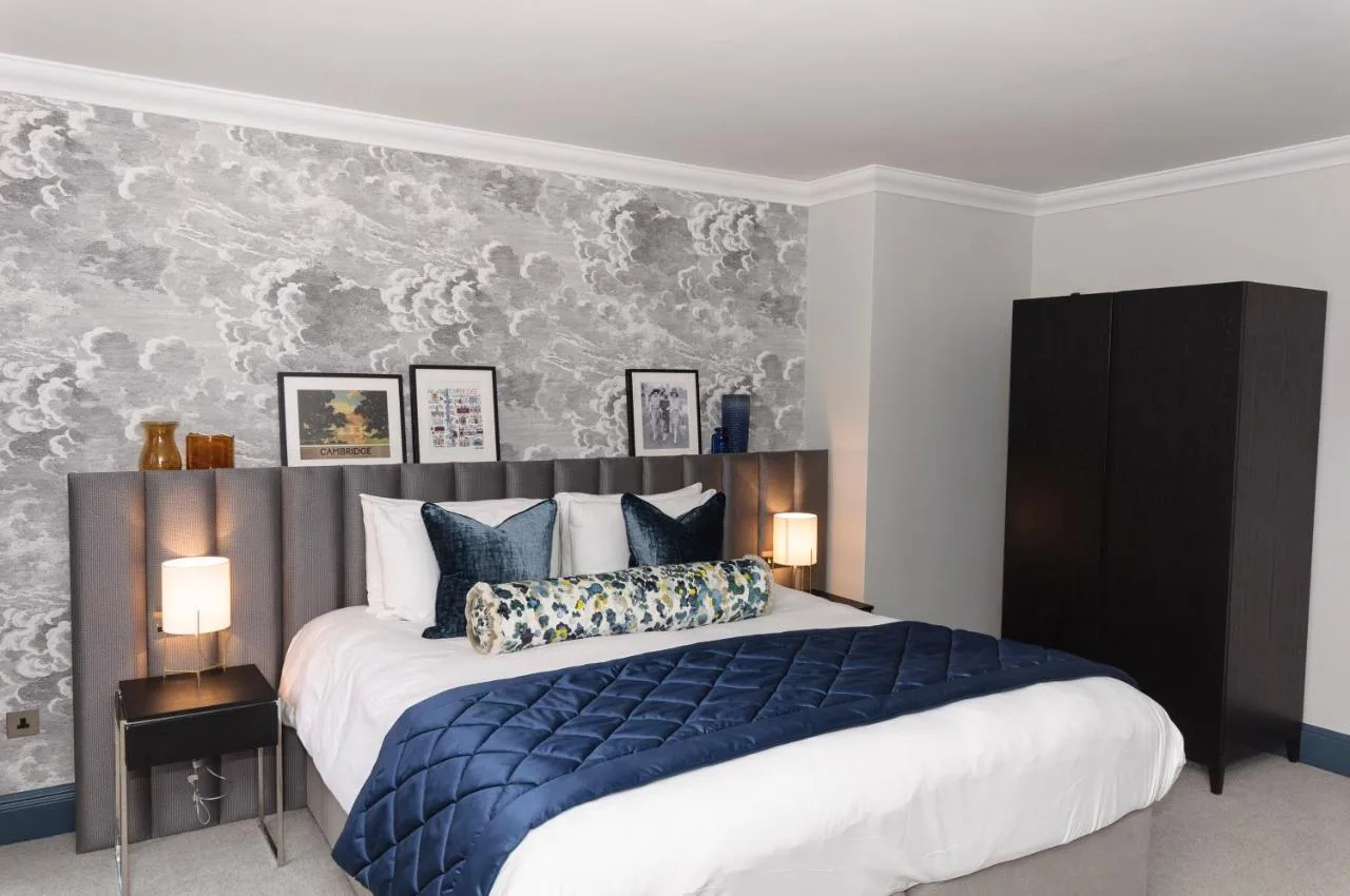 a bedroom with a large bed with a blue blanket at The Gonville Hotel, a member of Radisson Individuals in Cambridge